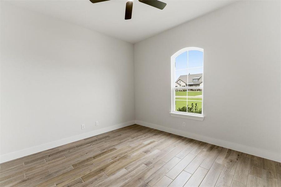 Spare room featuring light wood-style flooring and ceiling fan