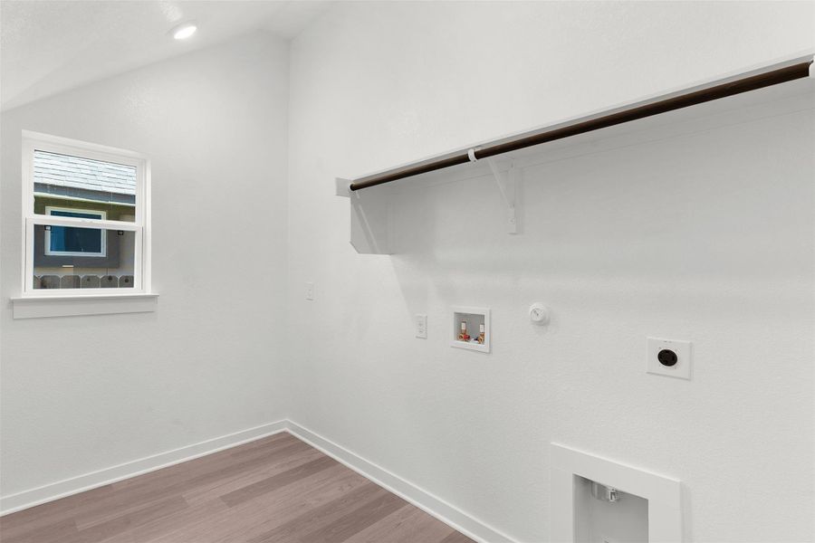 Washroom with gas dryer hookup, wood finished floors, washer hookup, and electric dryer hookup Washroom with gas dryer hookup, wood finished floors, washer hookup, and electric dryer hookup