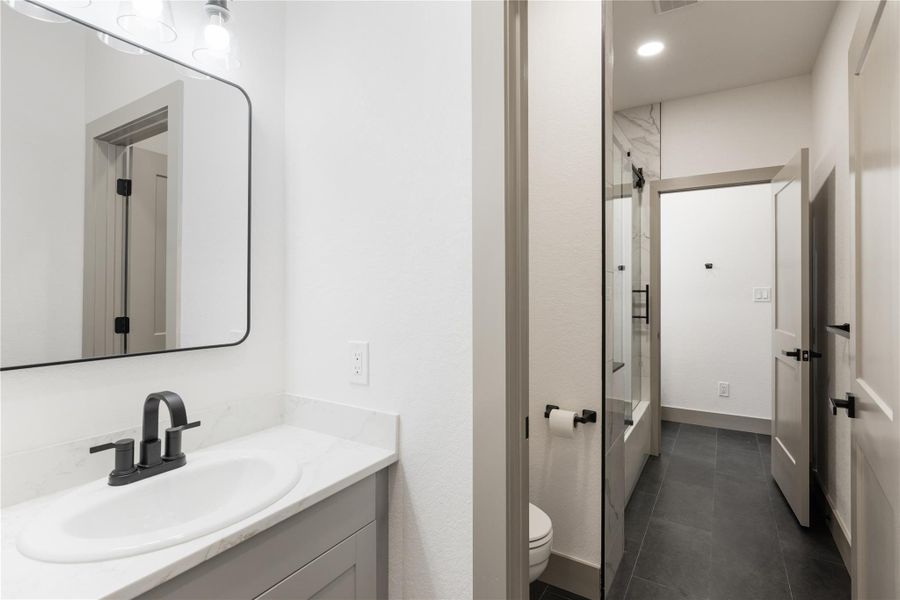 Full bathroom with visible vents, toilet, bathtub / shower combination, tile patterned floors, and vanity