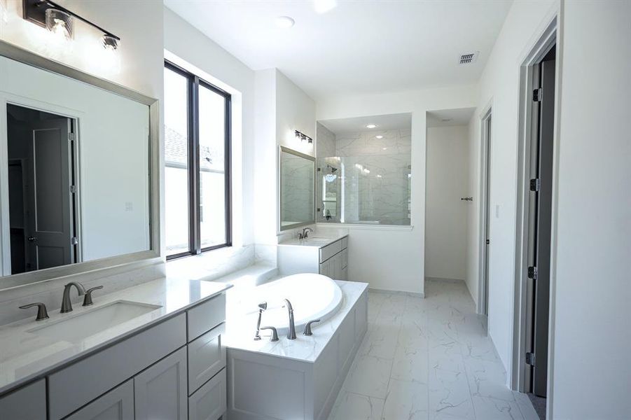 Master Bathroom with double vanities and walk-in shower and separate tub