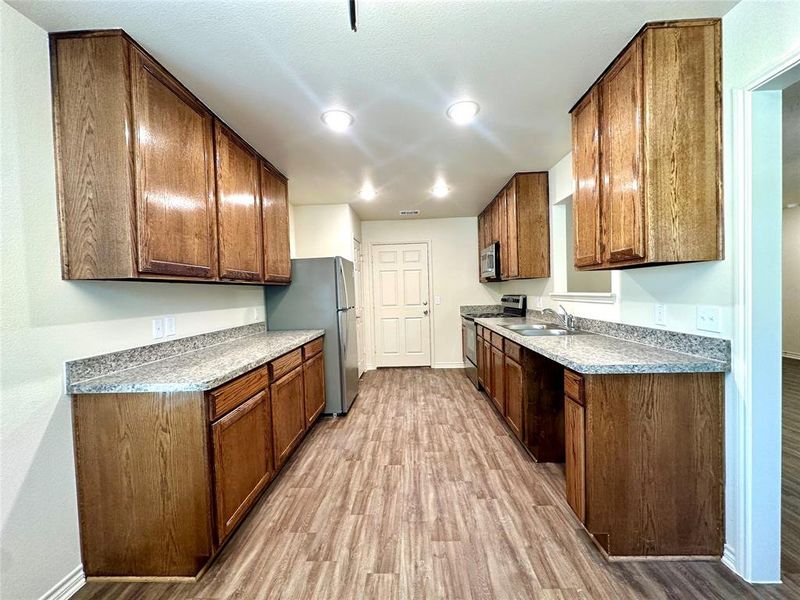 Kitchen with sink, appliances with stainless steel finishes, and light wood-type flooring