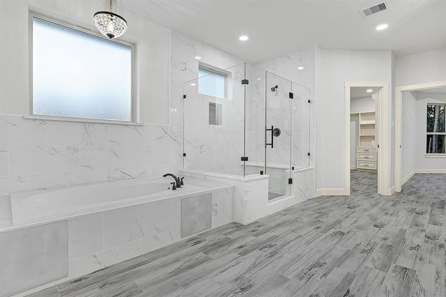 Master Bathroom with separate tub and large shower with a bench