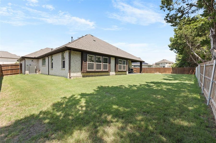 Expansive grass lawn with a full privacy fence and mature trees Expansive grass lawn with a full privacy fence and mature trees