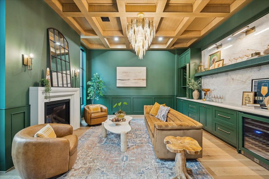 Rich green millwork, a coffered ceiling, and warm textures shape a refined yet welcoming study, complete with custom built-ins, Emtek hardware, and a cozy fireplace. An integrated Avallon beverage center enhances flexibility, making the room equally suited for an office, reading lounge, or listening room. The first floor features impressive 12 ft ceilings for an even more expansive feel.