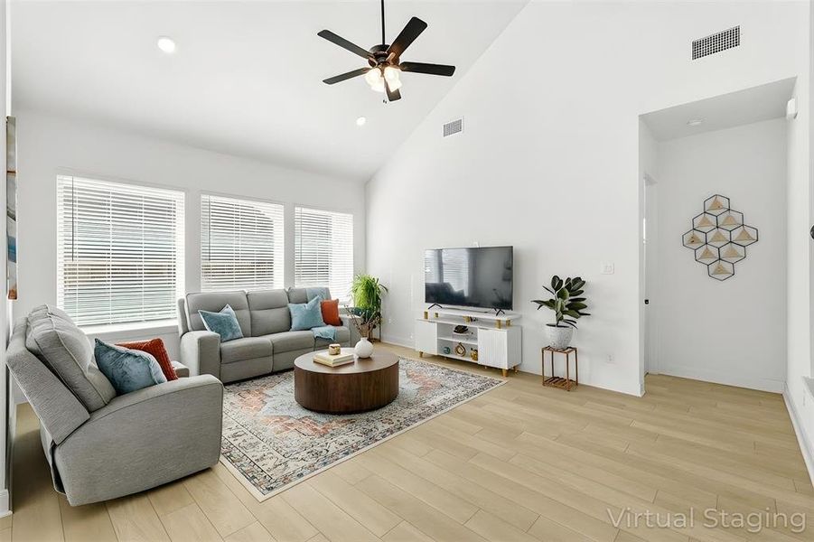 Living area with a ceiling fan, light wood-style floors, vaulted ceiling, and recessed lighting Living area with a ceiling fan, light wood-style floors, vaulted ceiling, and recessed lighting