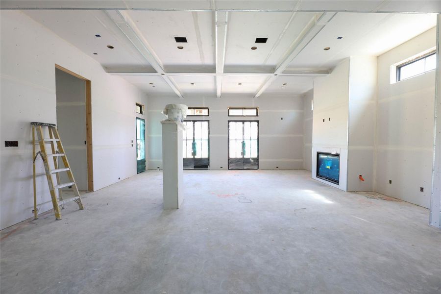 Spacious Family Room offers 12' ceilings, ceiling beam detail, gas fireplace, transom windows and several metal frame doors leading to the covered patio and back yard.