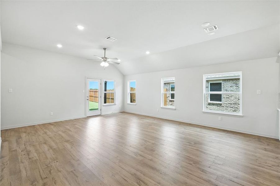 Unfurnished room featuring light wood-style flooring, recessed lighting, vaulted ceiling, and ceiling fan Unfurnished room featuring light wood-style flooring, recessed lighting, vaulted ceiling, and ceiling fan