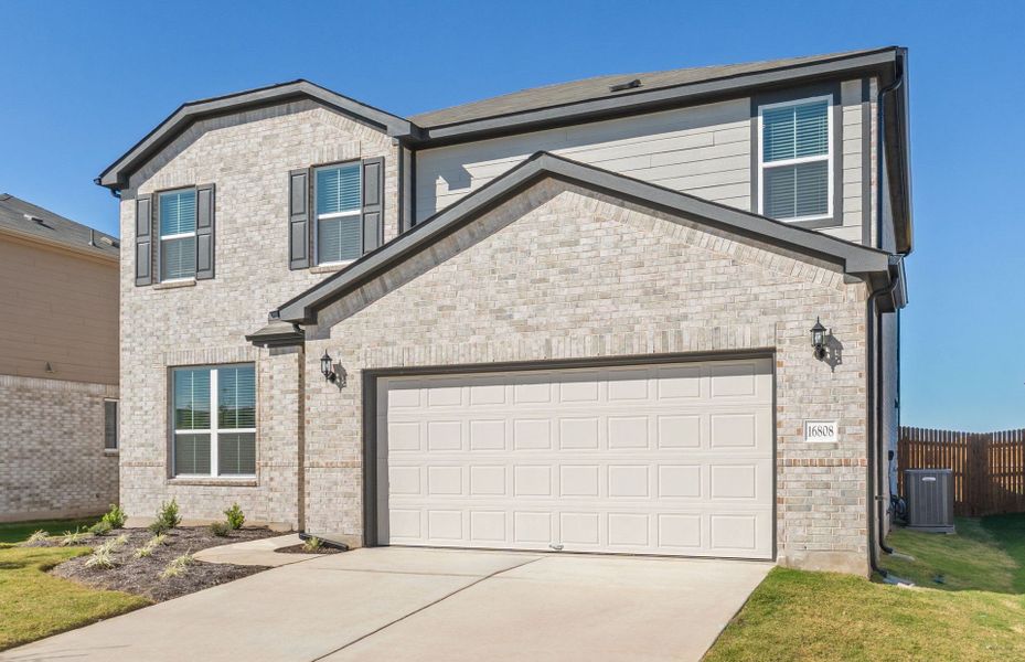 Front exterior of a new home in Lagos, Manor, TX, highlighting curb appeal (Image 18). Front exterior of a new home in Lagos, Manor, TX, highlighting curb appeal (Image 18).