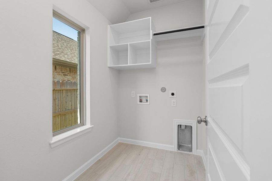 Dedicated interior laundry room with storage cabinetry and space for a full-size washer and dryer.