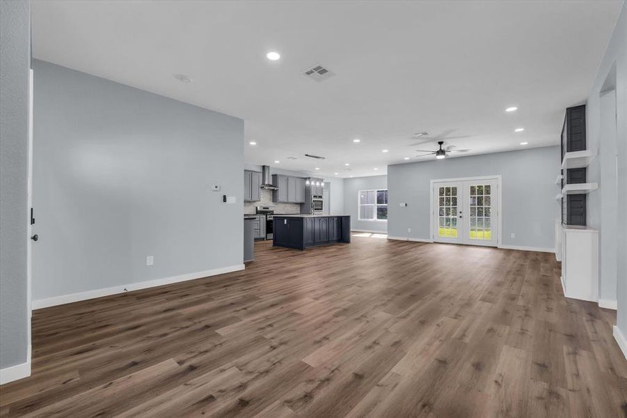 Unfurnished living room featuring french doors, recessed lighting, dark wood finished floors, and a ceiling fan Unfurnished living room featuring french doors, recessed lighting, dark wood finished floors, and a ceiling fan