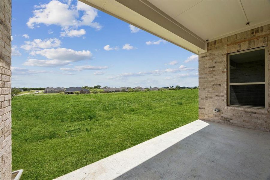 View of green lawn with a patio area
