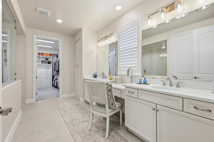 Full bath with a walk in closet, two vanities, and recessed lighting
