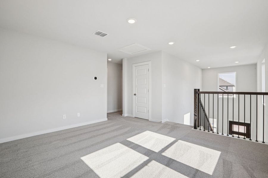 A room with a rug and a railing.