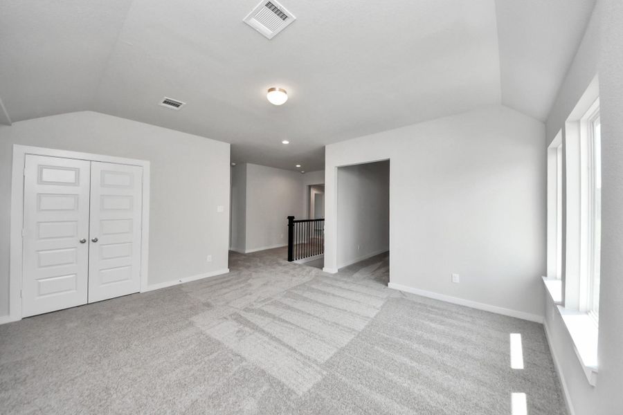 Come upstairs and enjoy a day of leisure in this fabulous game room! This is the perfect hangout spot or adult game room! Features plush carpet, high ceilings, custom paint and windows for plenty of natural light. Sample photo of completed home with similar floor plan. Actual colors and selections may vary.