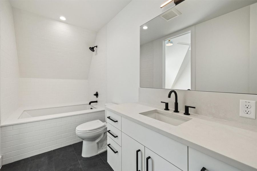 Full bathroom featuring vanity, recessed lighting, tiled shower / bath, and dark tile patterned floors
