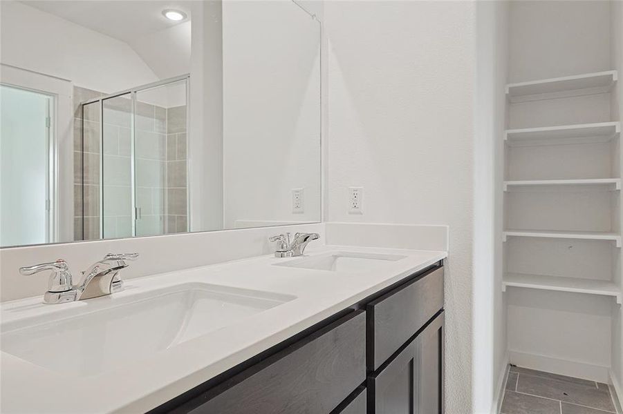 Bathroom with vanity, tile patterned floors, and a shower with door