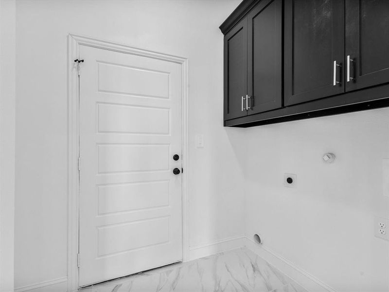 Washroom with hookup for an electric dryer, cabinet space, baseboards, light marble finish floors, and gas dryer hookup