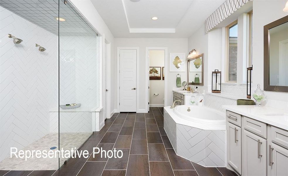 Bathroom with tile patterned floors, independent shower and bath, and dual bowl vanity