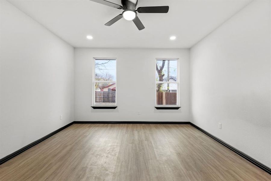 Master bedroom with light hardwood / wood-style floors and ceiling fan