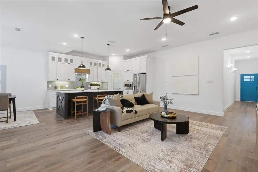 Living room featuring ceiling fan, recessed lighting, and dark wood-style flooring