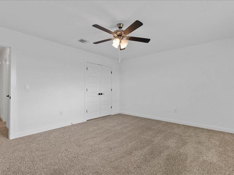 Spare room featuring light carpet and a ceiling fan