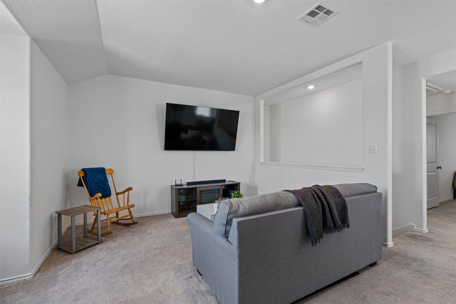 Living area with light carpet, lofted ceiling, and recessed lighting