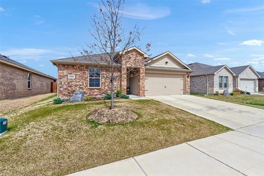 Ranch-style house featuring a front yard, a garage, brick siding, and concrete driveway