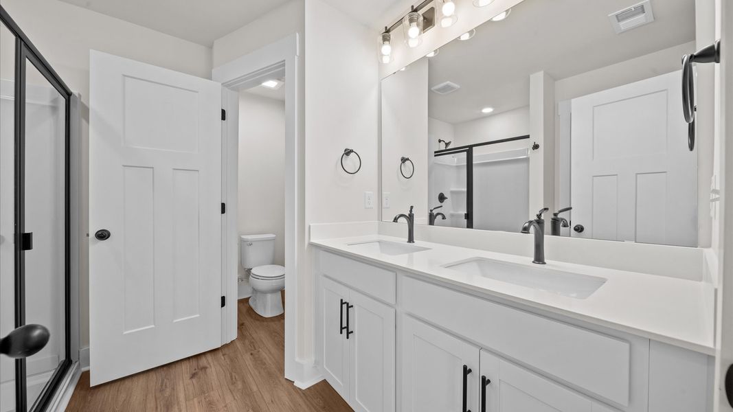 Exceptional en-suite with dual vanity and glass-enclosed walk-in shower for superior everyday comfort Exceptional en-suite with dual vanity and glass-enclosed walk-in shower for superior everyday comfort