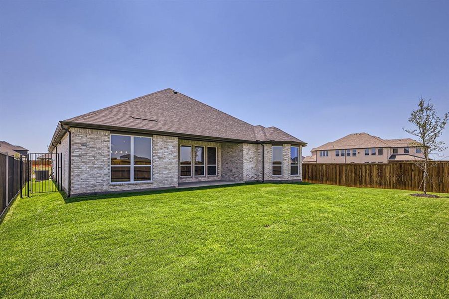Back of house featuring a shingled roof and brick siding Back of house featuring a shingled roof and brick siding