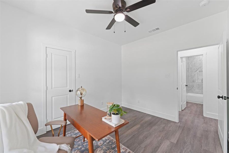 Versatile room featuring wood-finish flooring, a contemporary ceiling fan, and white baseboards Versatile room featuring wood-finish flooring, a contemporary ceiling fan, and white baseboards