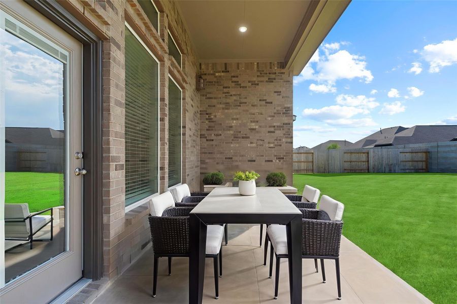 Virtually Staged – Covered patio styled for outdoor dining, perfect for entertaining or enjoying a quiet evening.