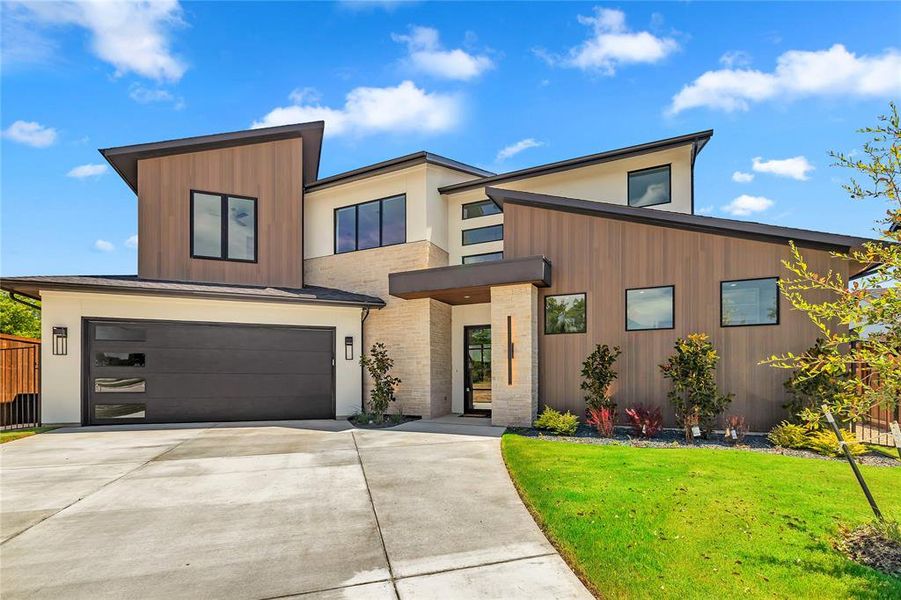 Contemporary house featuring a front yard, concrete driveway, an attached garage, and stucco siding Contemporary house featuring a front yard, concrete driveway, an attached garage, and stucco siding