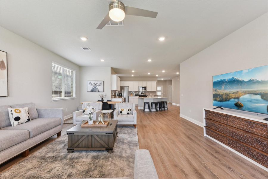 Living area with light wood-style floors, a ceiling fan, and recessed lighting Living area with light wood-style floors, a ceiling fan, and recessed lighting