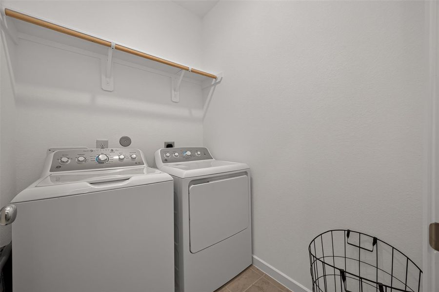 A bright and functional laundry room and convenient overhead shelf for storage.