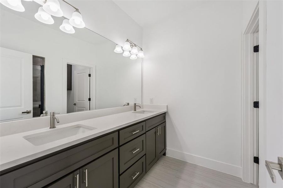 Bathroom featuring double vanity and light wood-type flooring