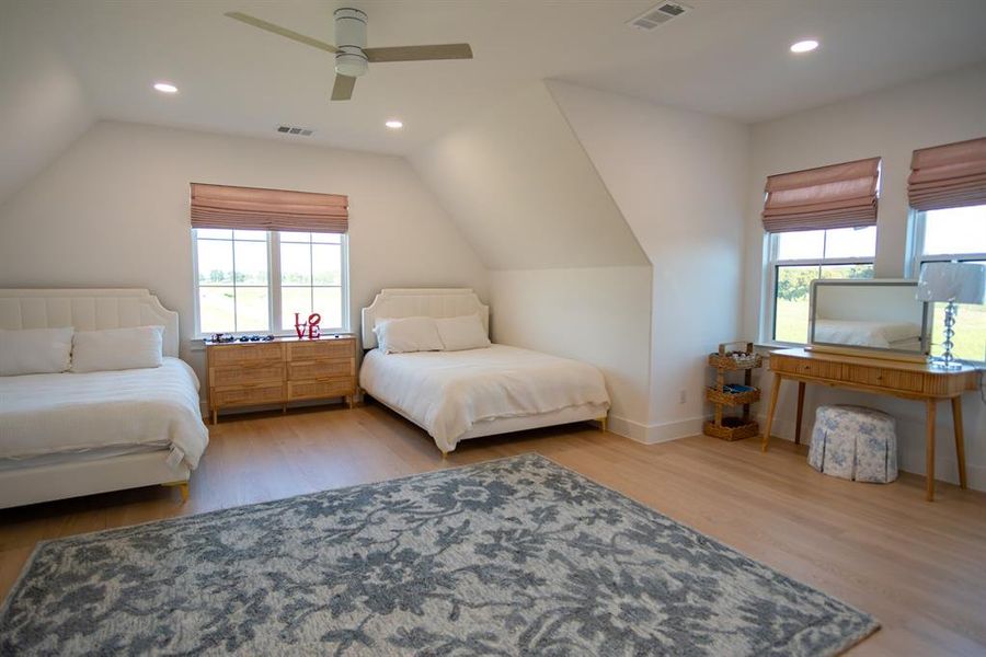 Bedroom featuring lofted ceiling, light wood-style flooring, recessed lighting, and a ceiling fan Bedroom featuring lofted ceiling, light wood-style flooring, recessed lighting, and a ceiling fan