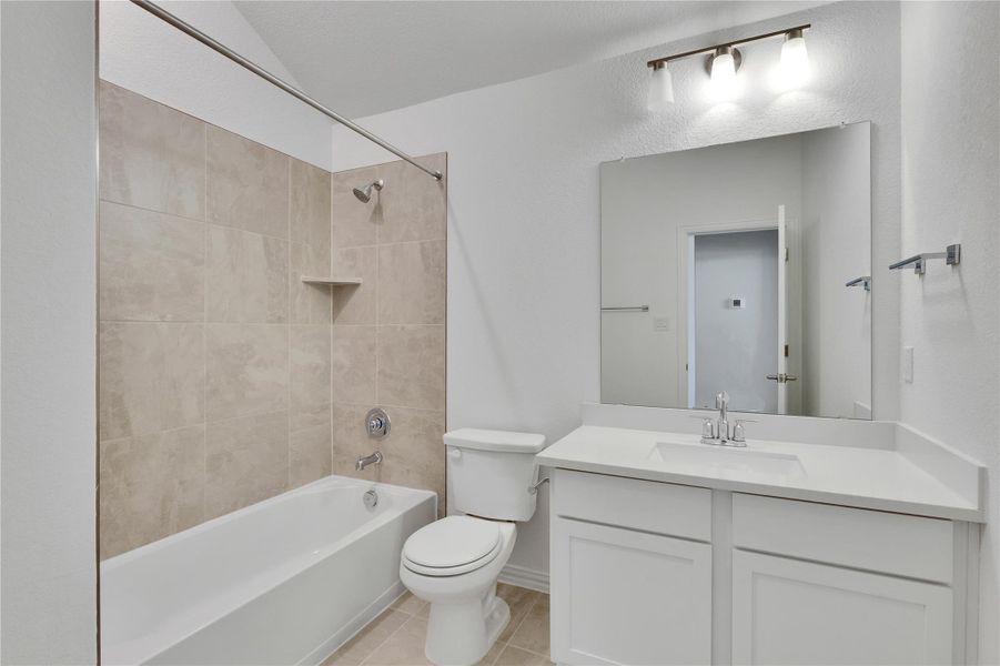 Full bathroom featuring bathing tub / shower combination, vanity, and light tile patterned floors Full bathroom featuring bathing tub / shower combination, vanity, and light tile patterned floors
