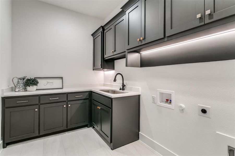 Laundry room with cabinet space, gas dryer hookup, washer hookup, electric dryer hookup, and light tile patterned floors