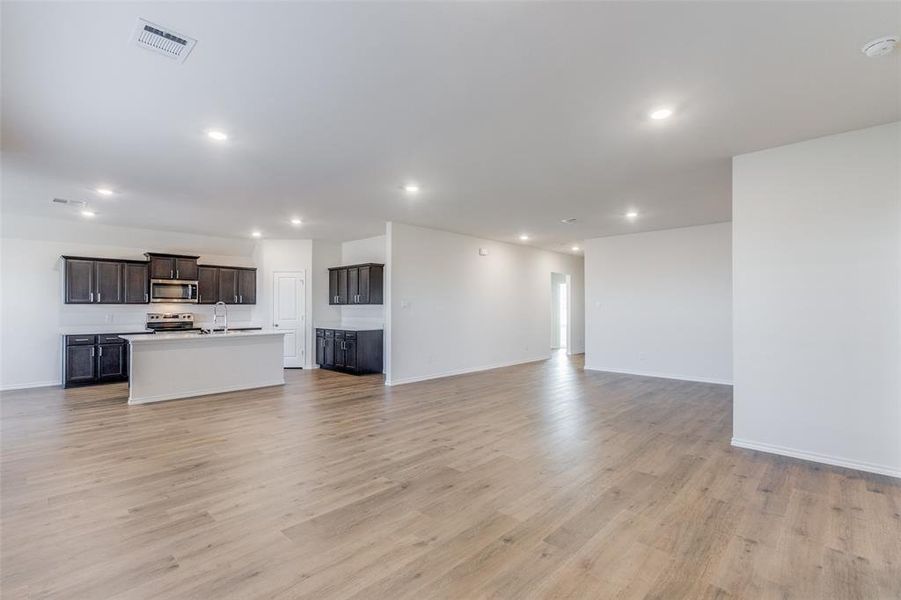 Unfurnished living room featuring light hardwood / wood-style flooring and sink