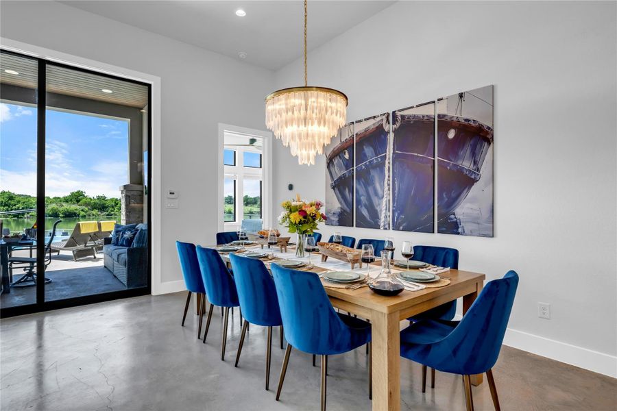 Expansive dining area featuring lake views, high ceilings, a show stopper chandelier.
