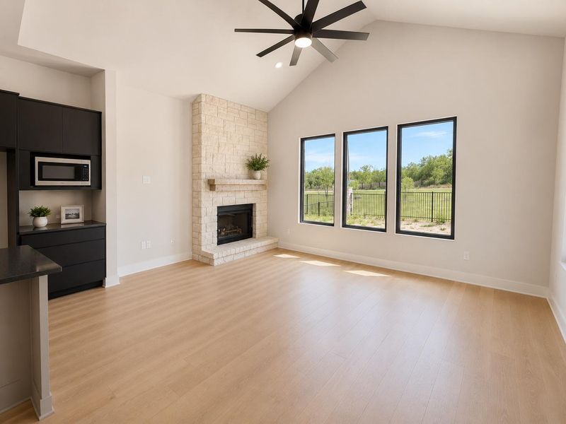 A spacious living area with vaulted ceilings and a floor-to-ceiling stone fireplace, complemented by natural light from large windows.