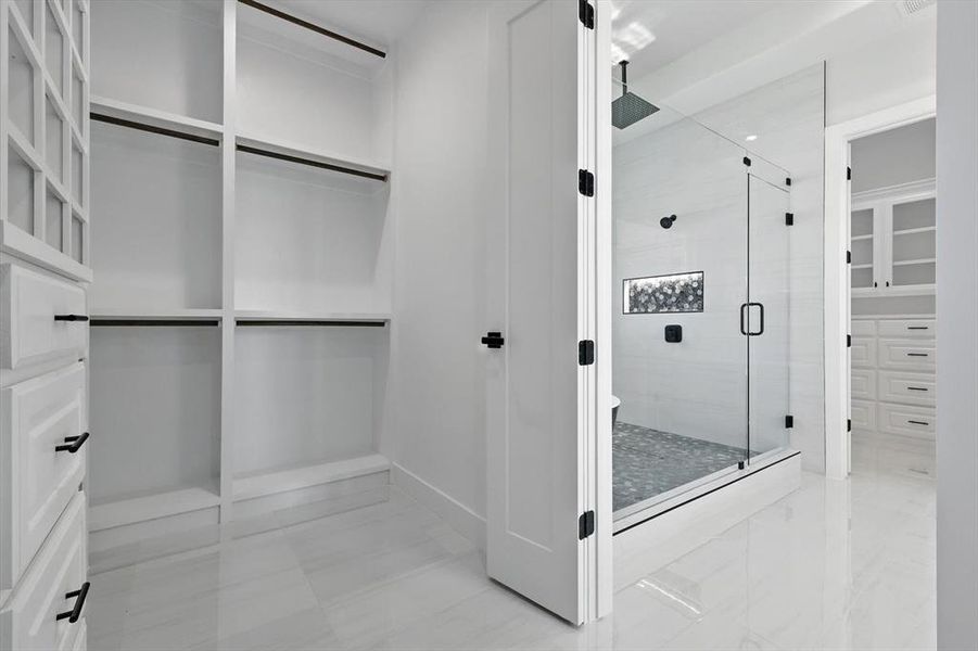 Bathroom featuring a stall shower and a walk in closet Bathroom featuring a stall shower and a walk in closet