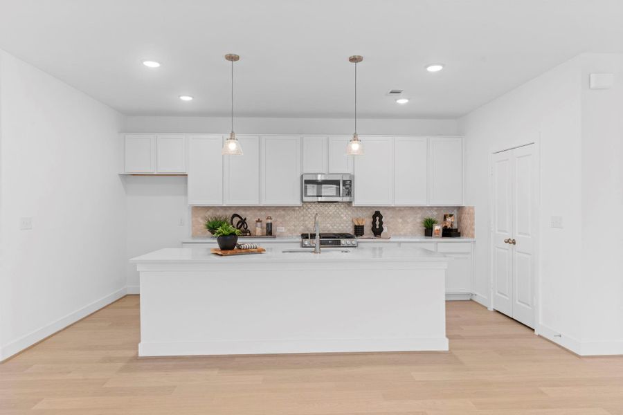 The gourmet kitchen will impress any home chef! Featuring sleek quartz countertops, tall white shaker cabinets, and a large island with pendant lighting — perfect for meal prep or morning coffee chats. **Image Representative of Plan Only and May Vary as Built**.