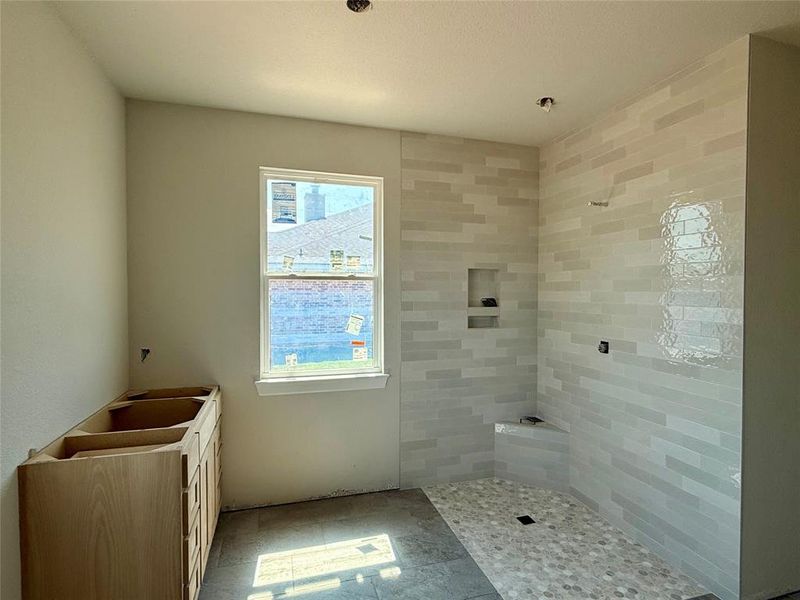 Bathroom with a tile shower, vanity, and tile patterned flooring Bathroom with a tile shower, vanity, and tile patterned flooring