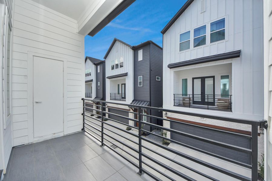 Step outside to enjoy this balcony view overlooking a row of contemporary townhouses. The space invites you to relax outdoors while enjoying the vibrant, well-kept neighborhood below.