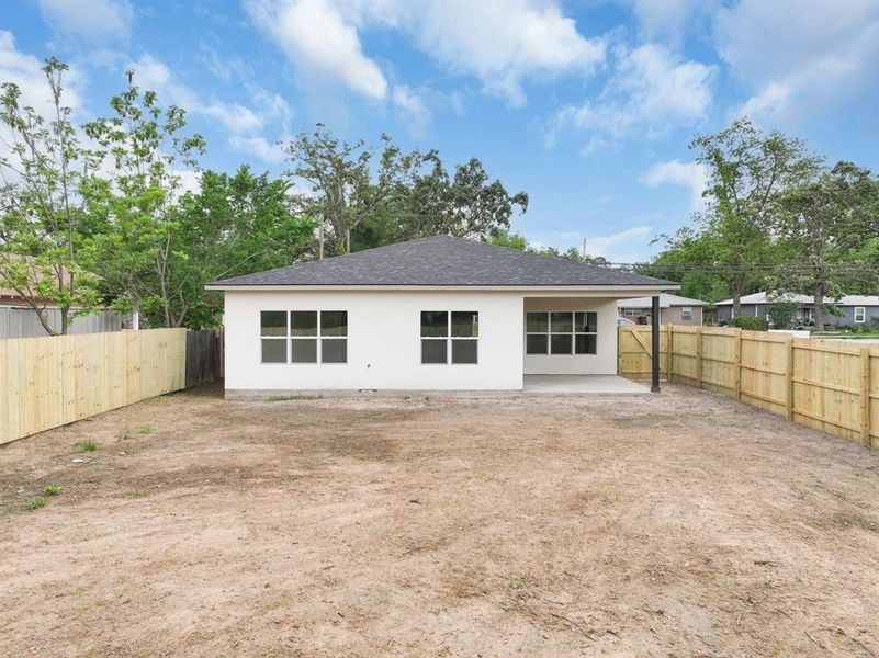 Back of house with a patio, a fenced backyard, and roof with shingles