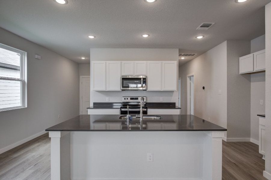 A kitchen with white cabinets.