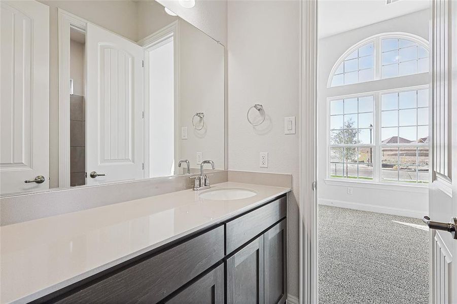 Bathroom featuring vanity and light carpet