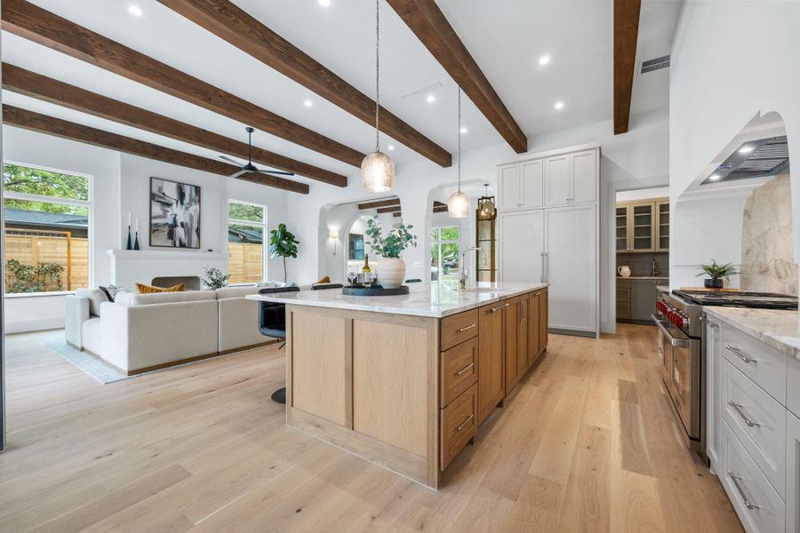 Kitchen with recessed lighting, premium appliances, hanging light fixtures, light stone countertops, and white cabinets Kitchen with recessed lighting, premium appliances, hanging light fixtures, light stone countertops, and white cabinets