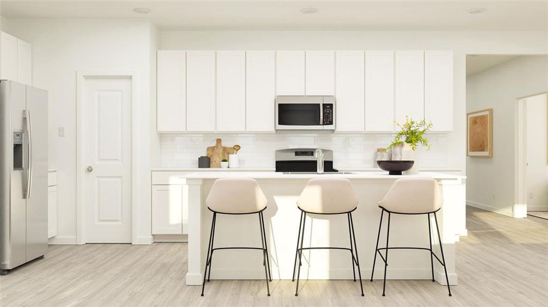 Kitchen featuring white cabinetry, stainless steel appliances, a center island with sink, and light hardwood / wood-style flooring